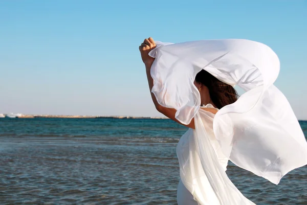 Женщина в белом на берегу моря — стоковое фото