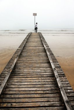 Teenage girl on old sea pier clipart