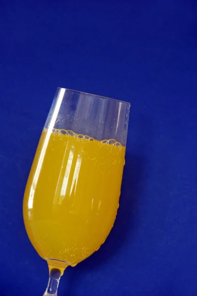 Yellow drink over blue — Stock Photo, Image