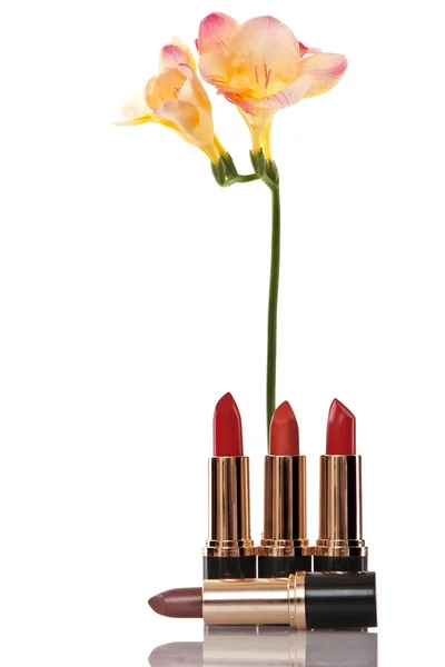Rouge à lèvres rouge glamour brillant et fleur jaune — Photo