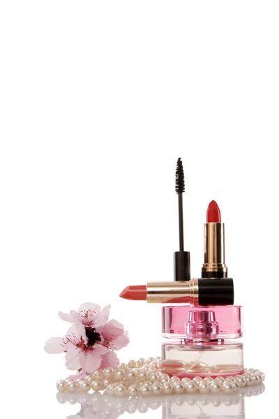 Contas de pérolas, cosméticos e flor de cereja — Fotografia de Stock