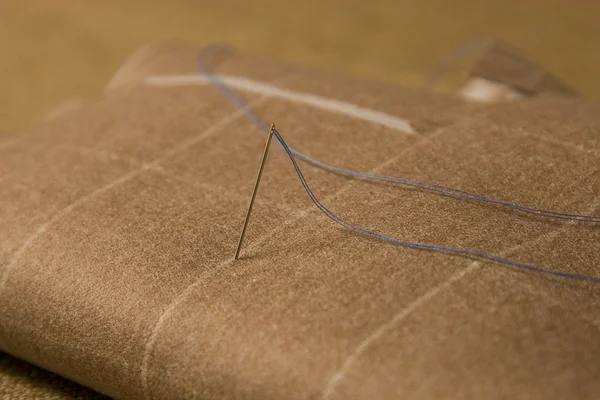 Needle and thread on fabric background — Stock Photo, Image
