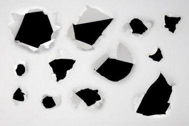 Closeup of a dark holes on white paper set clipart