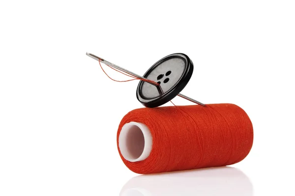 Red spool, black button and needle — Stock Photo, Image