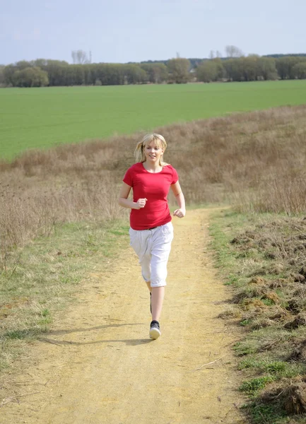 Frau joggt auf Feldweg — Stockfoto