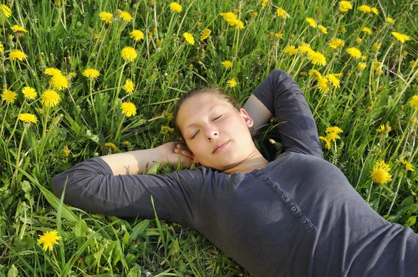 Mujer yace en un prado de flores — Foto de Stock