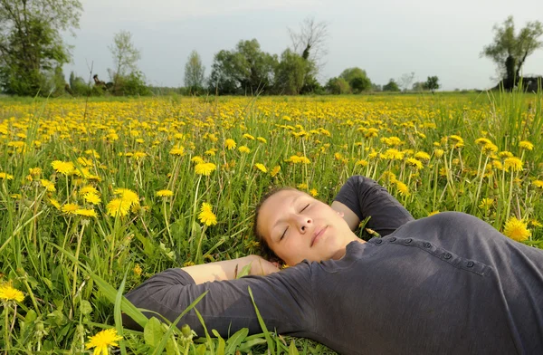 Frau liegt auf einer Blumenwiese — Stockfoto