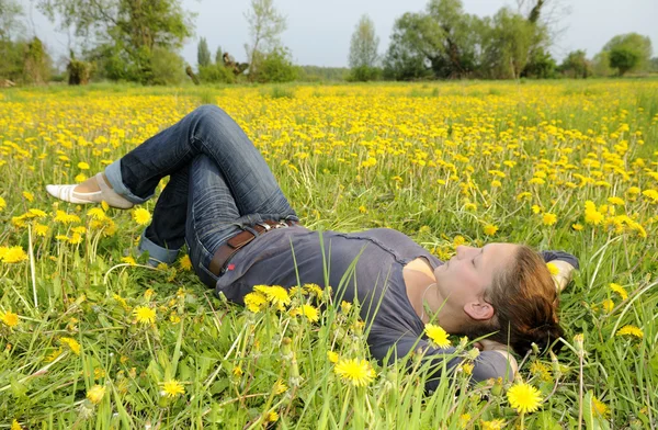 Woman lies on a flower meadow — Stock Photo, Image