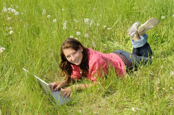 Kobieta z laptopa na łące — Zdjęcie stockowe