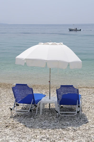 Шезлонги и зонтики на пляже — стоковое фото