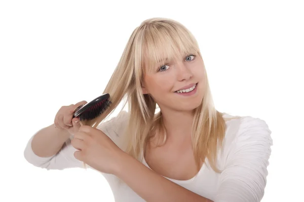 Joven mujer peinándose el pelo — Foto de Stock
