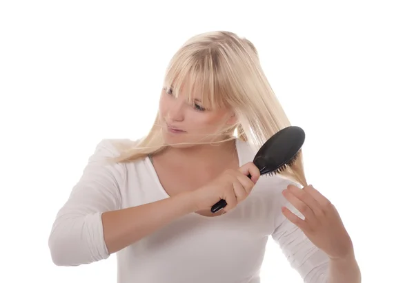 Joven mujer peinándose el pelo — Foto de Stock