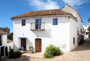 Narrow, cobbled streets and houses of Spanish Pueblo clipart