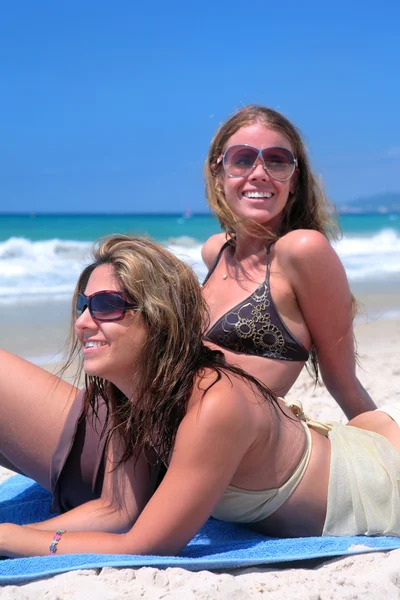 두 섹시 한 젊은 여자는 모래 해변에 일광욕 스톡 이미지