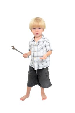 Isolated shot of young boy playing with large spanner clipart