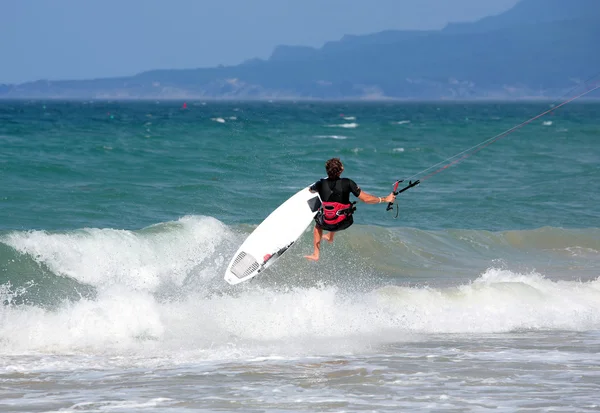 Joven kitesurfer macho saltando sobre el mar —  Fotos de Stock