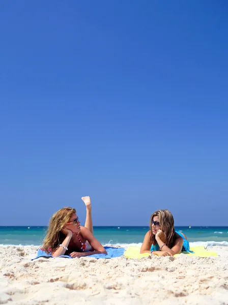 Dvě mladé, atraktivní ženy ležící na pláži — Stock fotografie