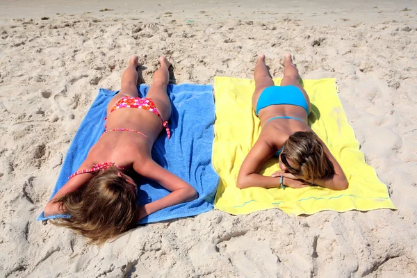 Dos chicas jóvenes sexy que yacen en una playa soleada de vacaciones o holi — Foto de Stock
