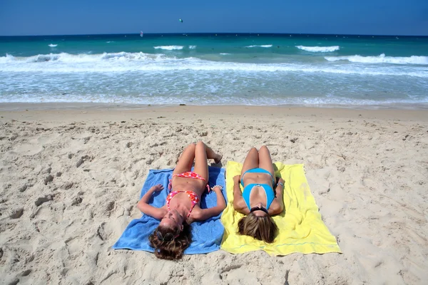 Dwóch młodych dziewcząt sexy, układanie na słonecznej plaży na wakacje lub holi — Zdjęcie stockowe