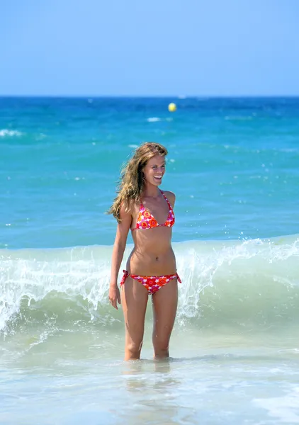 Sexy en forma y bronceado joven mujer siendo salpicado por una ola —  Fotos de Stock