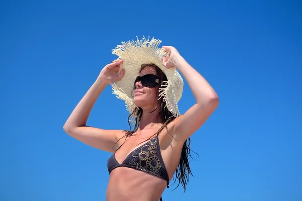 Sexig kvinna i bikini justera hatt — Stockfoto