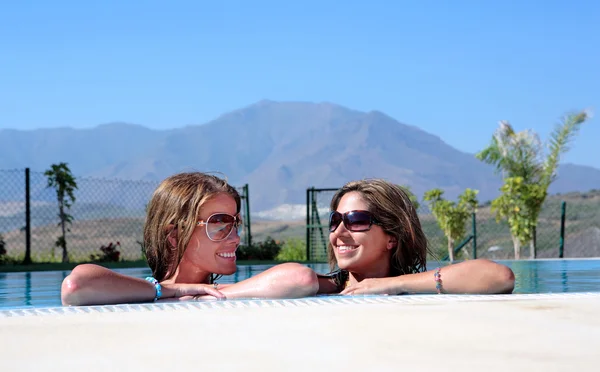 Dos amigas disfrutando del sol mientras están de vacaciones o de vacaciones —  Fotos de Stock