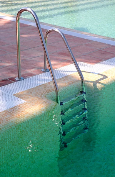 Steps leading out of clear green swimming pool — Stock Photo, Image
