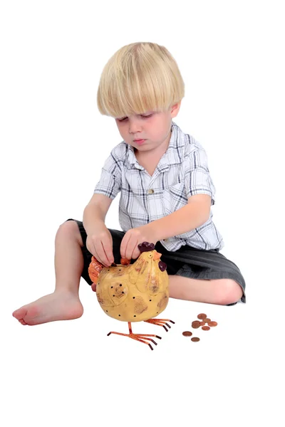 Jonge jongen geld steken in een piggy bank — Stockfoto