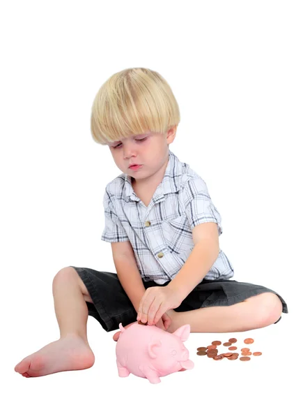 stock image Young boy putting money into a piggy bank
