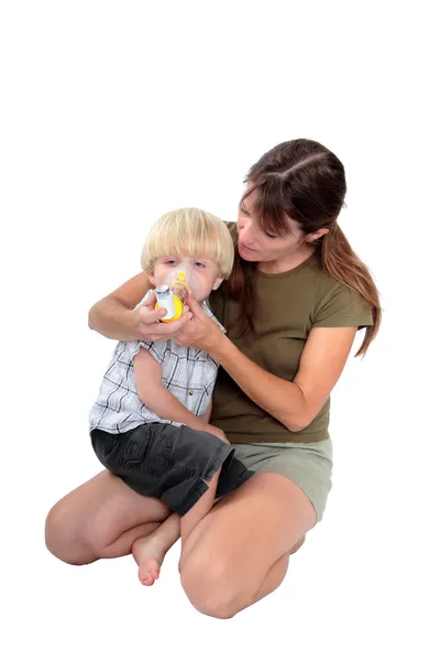Jovem mãe dando medicina respiratória para seu filho — Fotografia de Stock