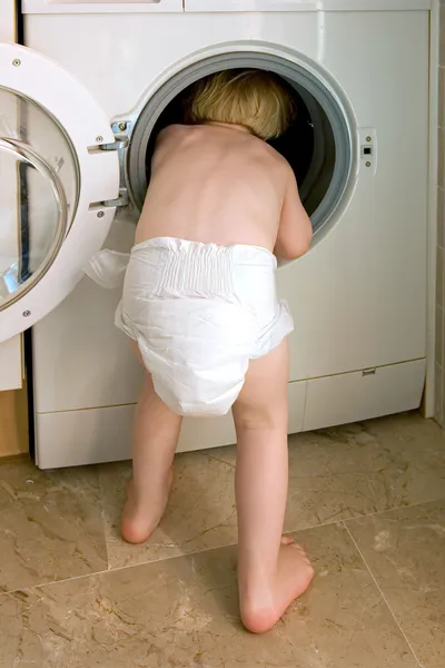 Fiatal gyerek mászó belső rész egy mosógép — Stock Fotó
