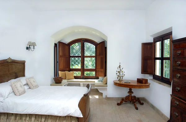 Rustik, vita, ljusa inredning sovrum i spanska villa Stockbild