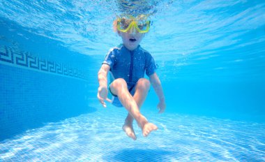 Young boy underwater in swimming pool clipart