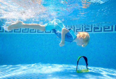 Young boy underwater in swimming pool clipart