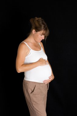 holding ve mide arayan genç hamile kadın yan görünüm