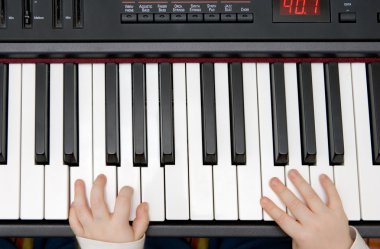 Young boys hands on an electronic piano or keyboard clipart