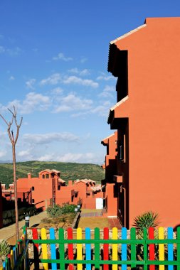 Salmon or orange apartments on Spanish urbanisation clipart