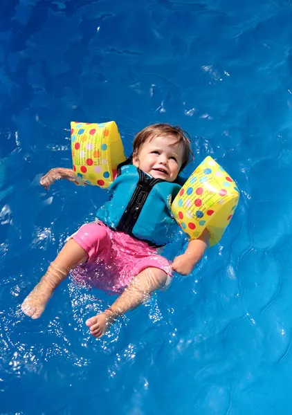 Дівчинка-малюк плаває над басейном — стокове фото