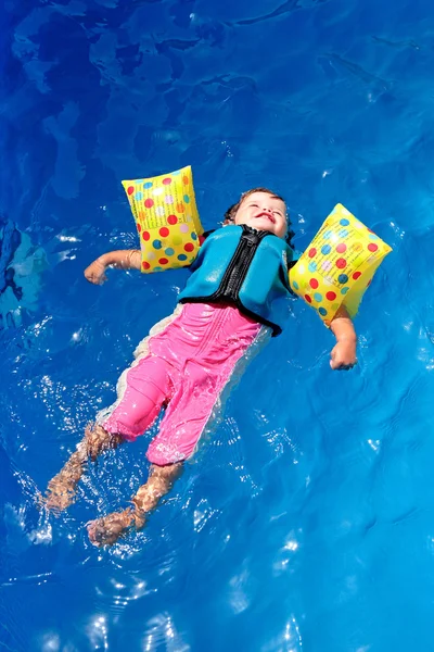 Дівчинка-малюк плаває над басейном — стокове фото
