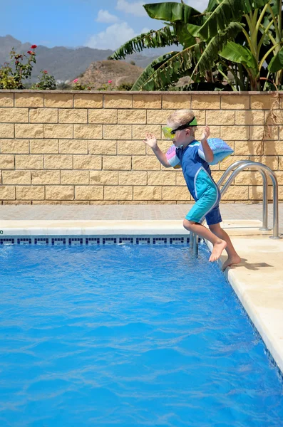 Giovane ragazzo che salta in piscina — Foto Stock