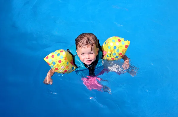 Κορίτσι μικρό παιδί που επιπλέει πάνω από την πισίνα — Φωτογραφία Αρχείου
