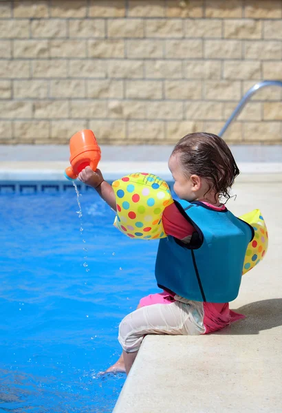 Дівчинка малюк сидить поруч з басейном — стокове фото