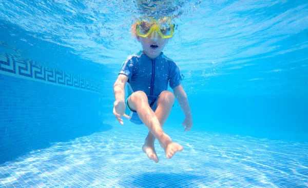 Jeune garçon sous l'eau dans la piscine — Photo