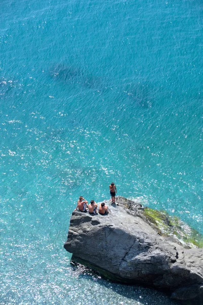 4 명의 젊은 소년가 서 일 보고 바위에 앉아 — 스톡 사진