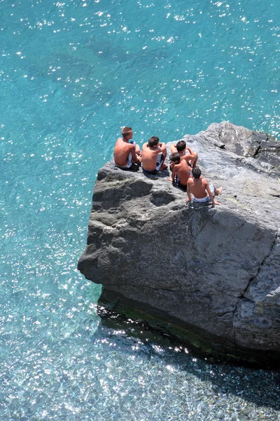 五个年轻男孩坐在岩石看去那天 — 图库照片