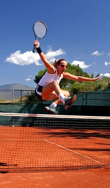 Girl jumping tennis net — Stock Photo, Image