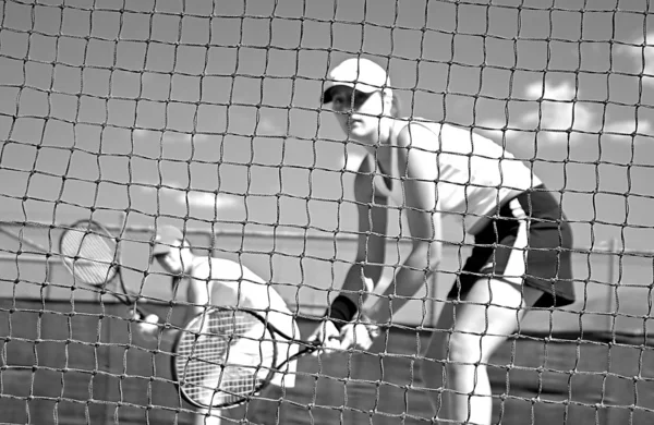 Vrouw tennisspelers kijken camera via net wachten aan pl — Stockfoto