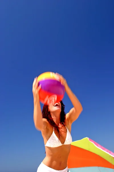 Fit and healthy woman catching beach ball on sunny beach in Spai — Stock Photo, Image