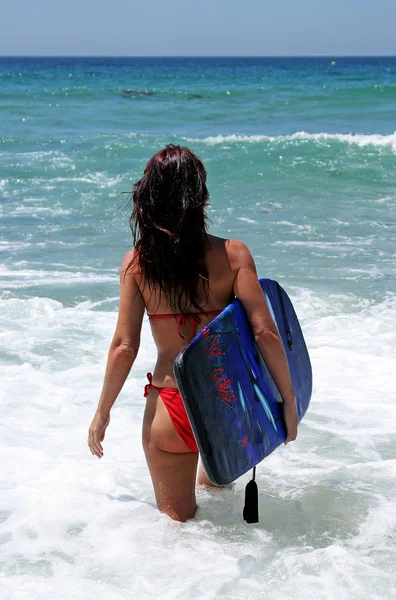 Sexy attraktive junge Frau im roten Bikini zu Fuß nach blau se — Stockfoto