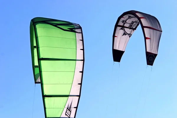 Kitesurfing a sárkányok ellen a kék ég — Stock Fotó